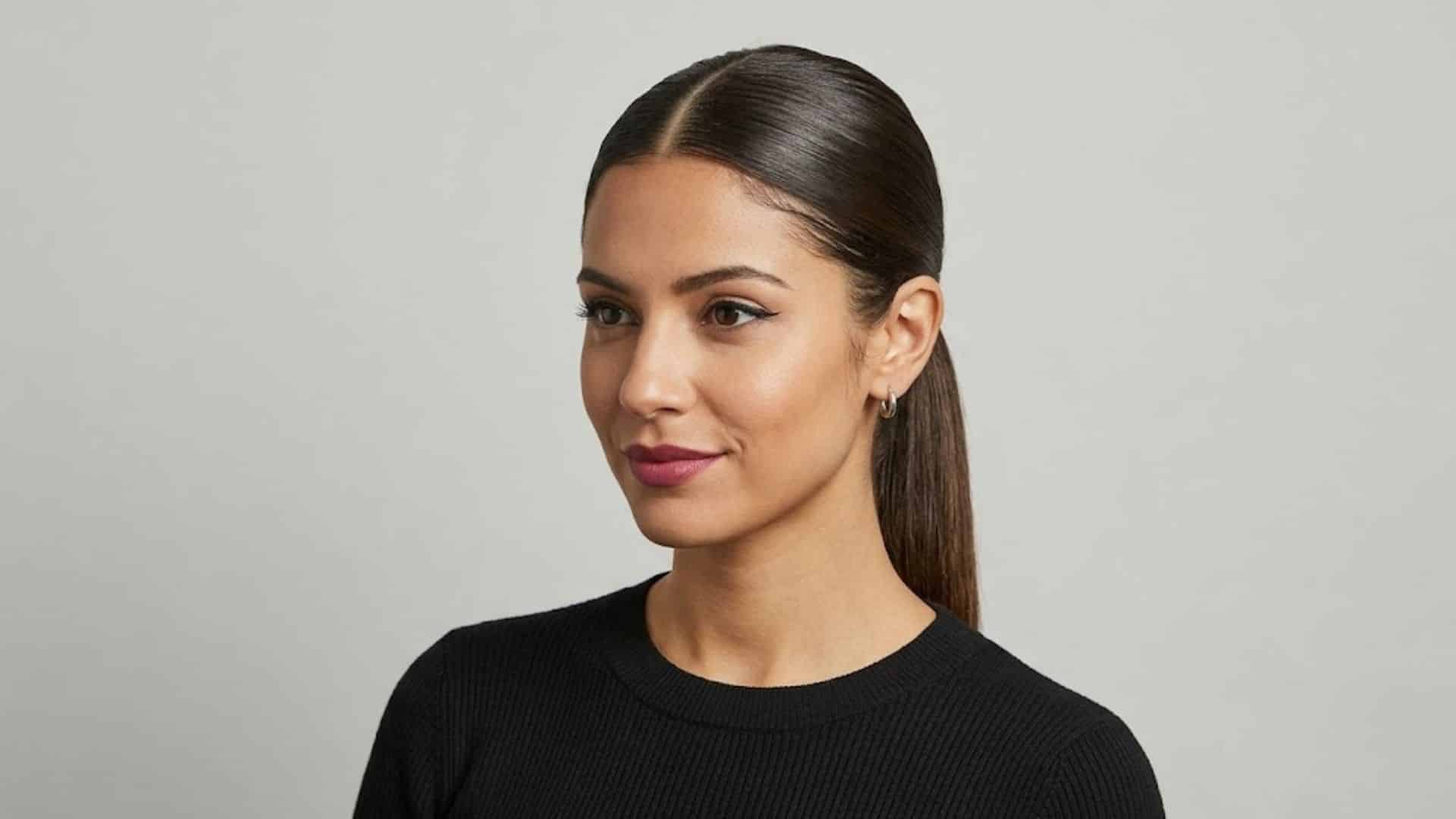 Woman with a middle-part slick ponytail and sleek straight hair