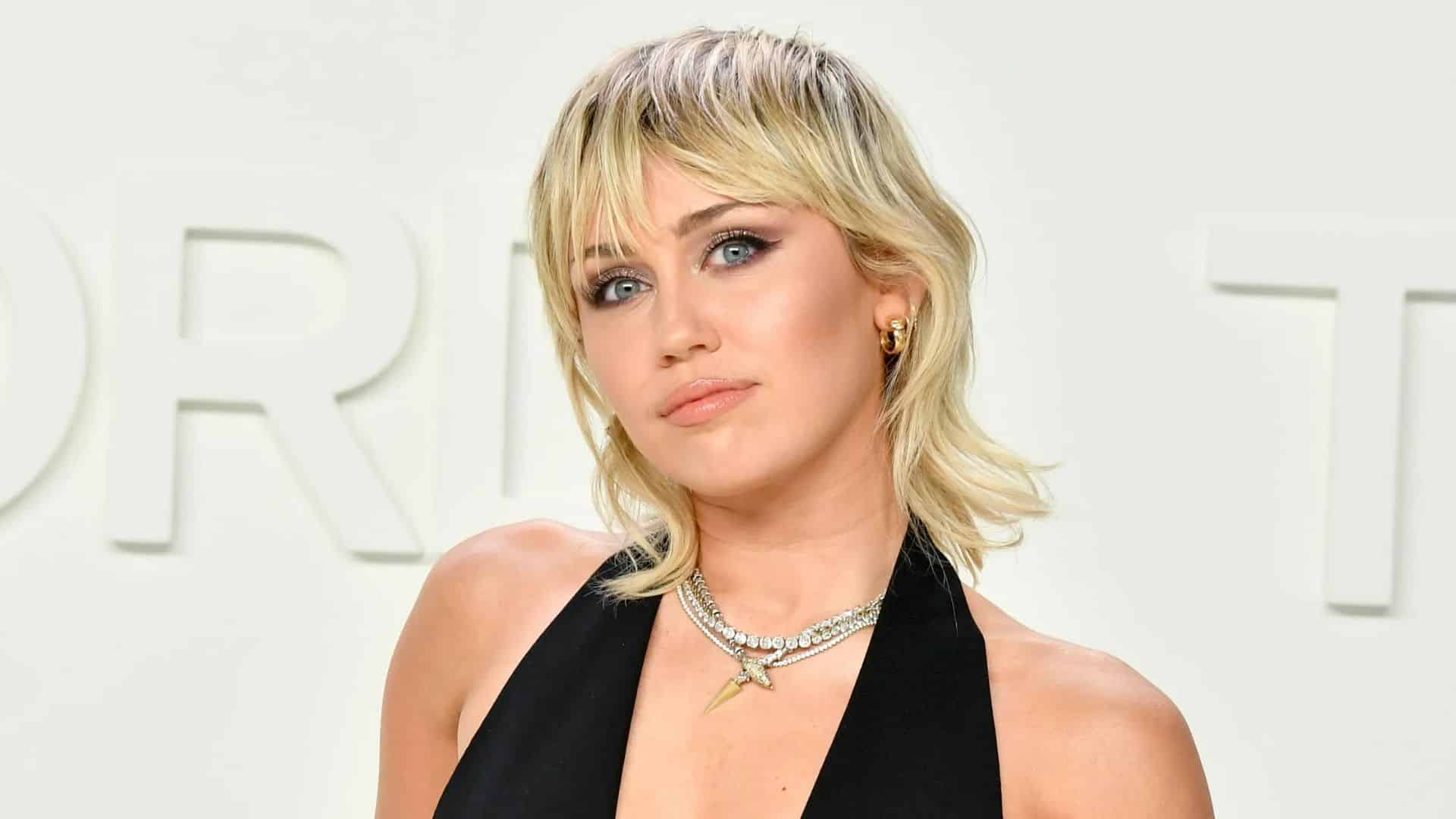 Miley Cyrus with a soft mullet haircut, blonde layers and shaggy bangs