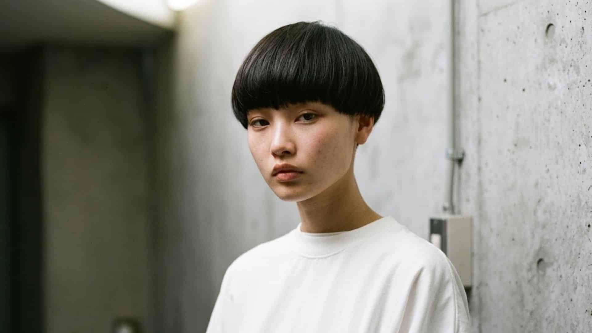 Modern bowl cut with blunt, straight bangs and sharp edges.