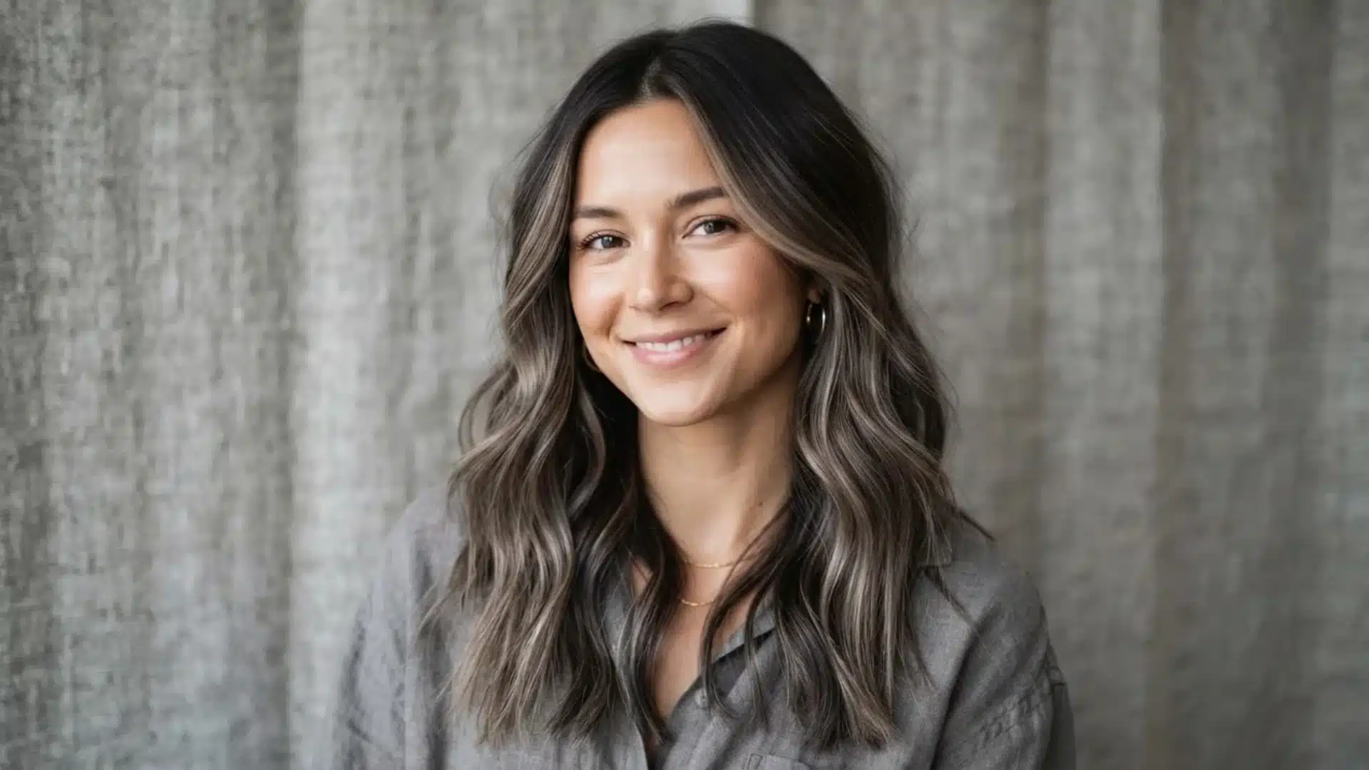 dark brown hair with mushroom brown balayage highlights on grey linen