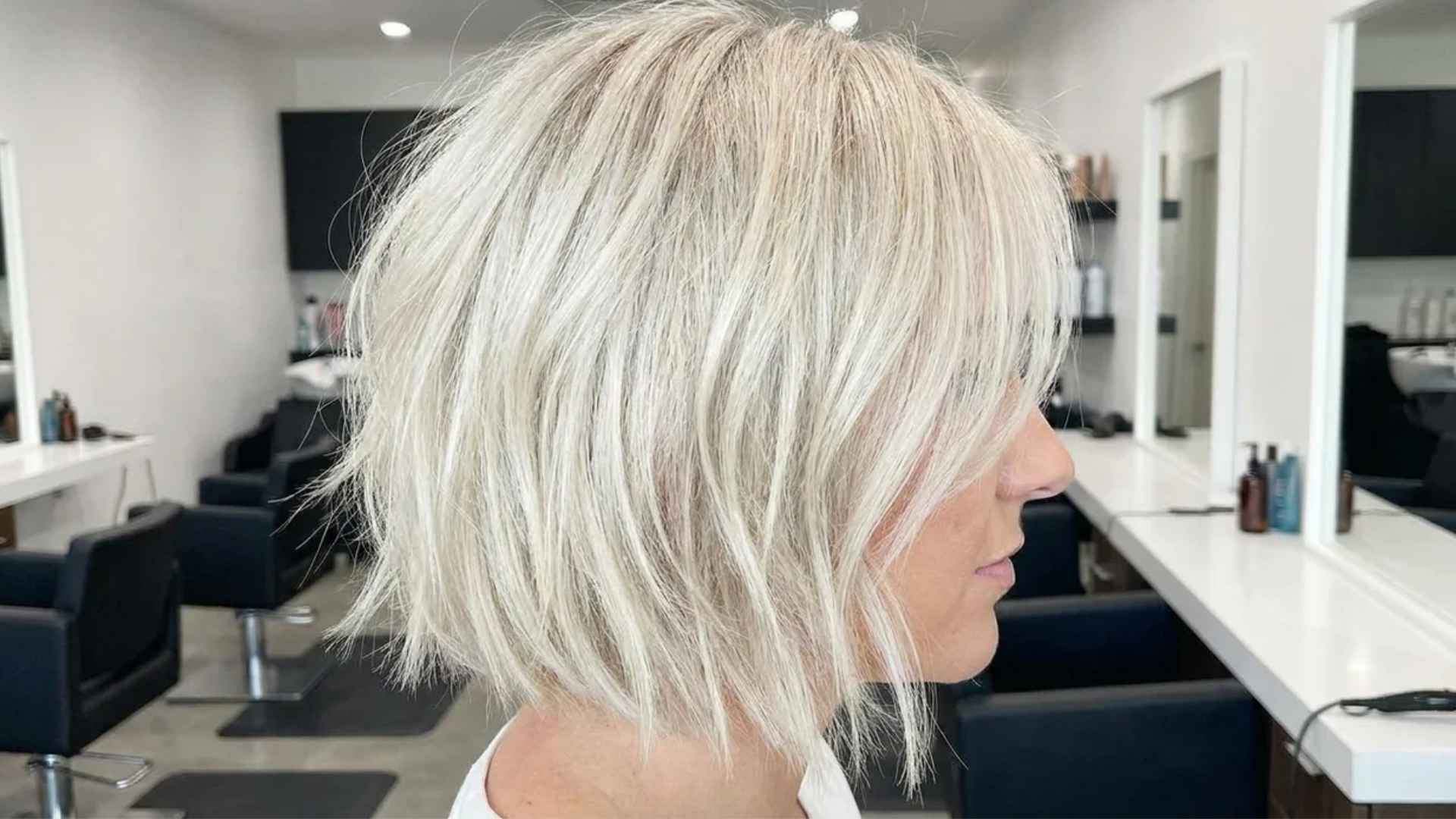 Woman with platinum layered bob featuring light blonde tone and soft textured layers with sleek shiny finish