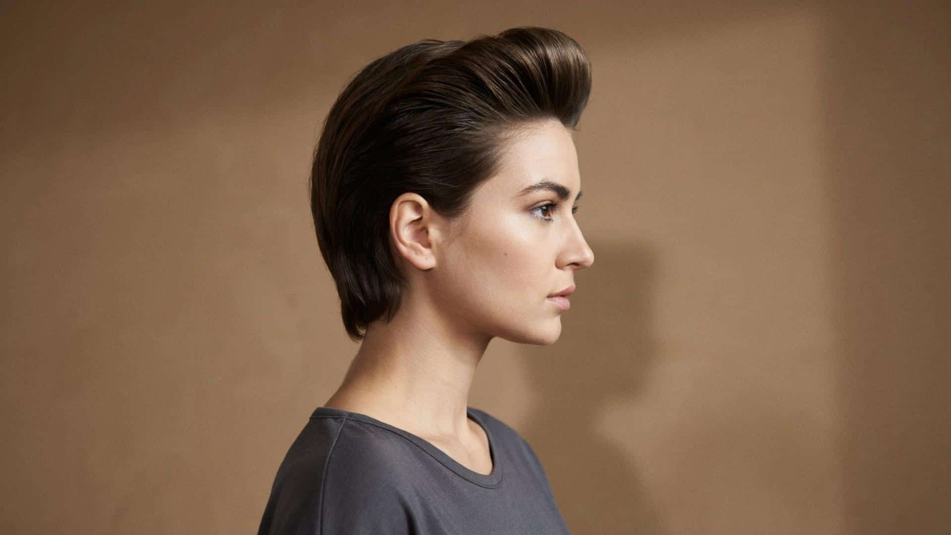 Sleek pompadour with height at the crown, side profile, glossy finish.