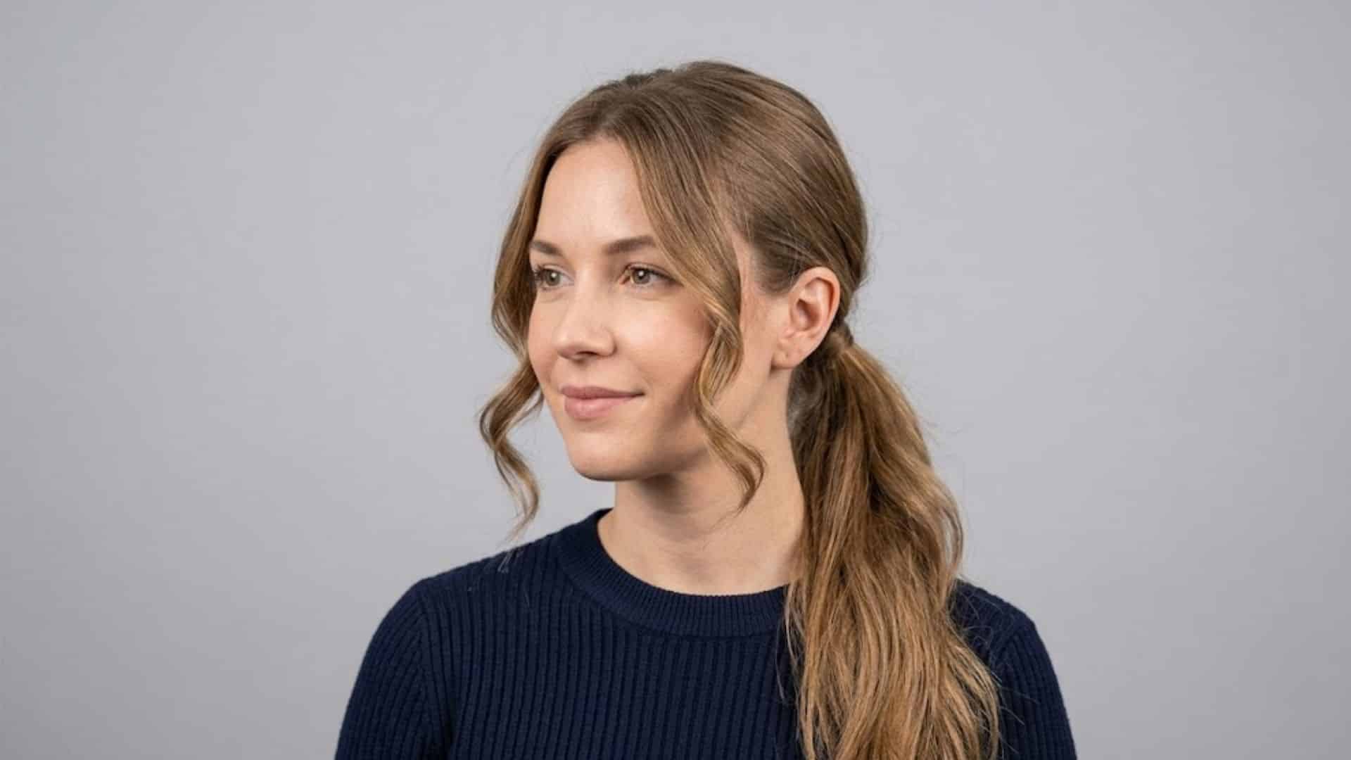 Low wavy ponytail with curled face-framing pieces left out