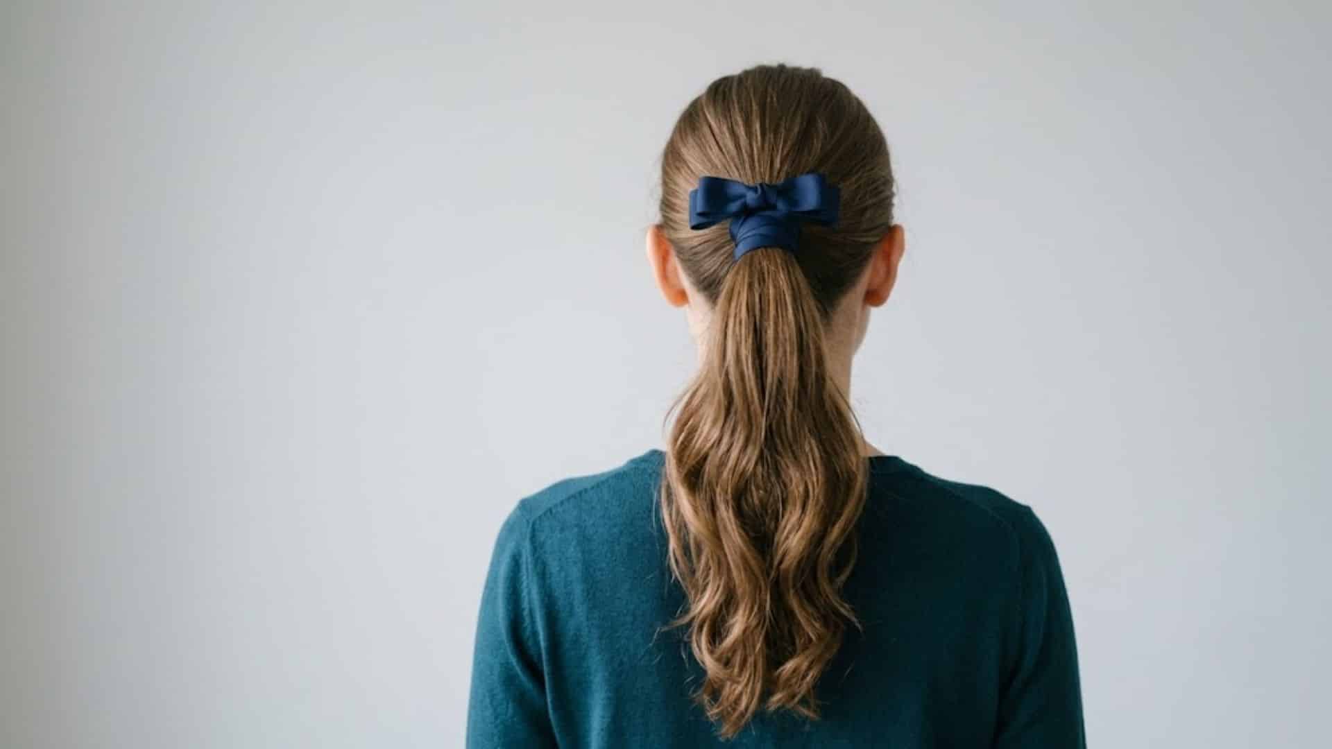 Wavy ponytail tied with a navy satin ribbon bow