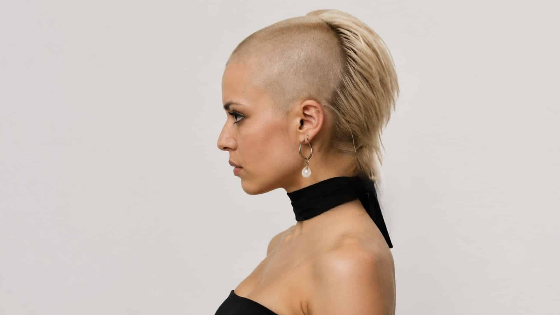 Woman with skullet cut as shaved-side and hair on back, side profile