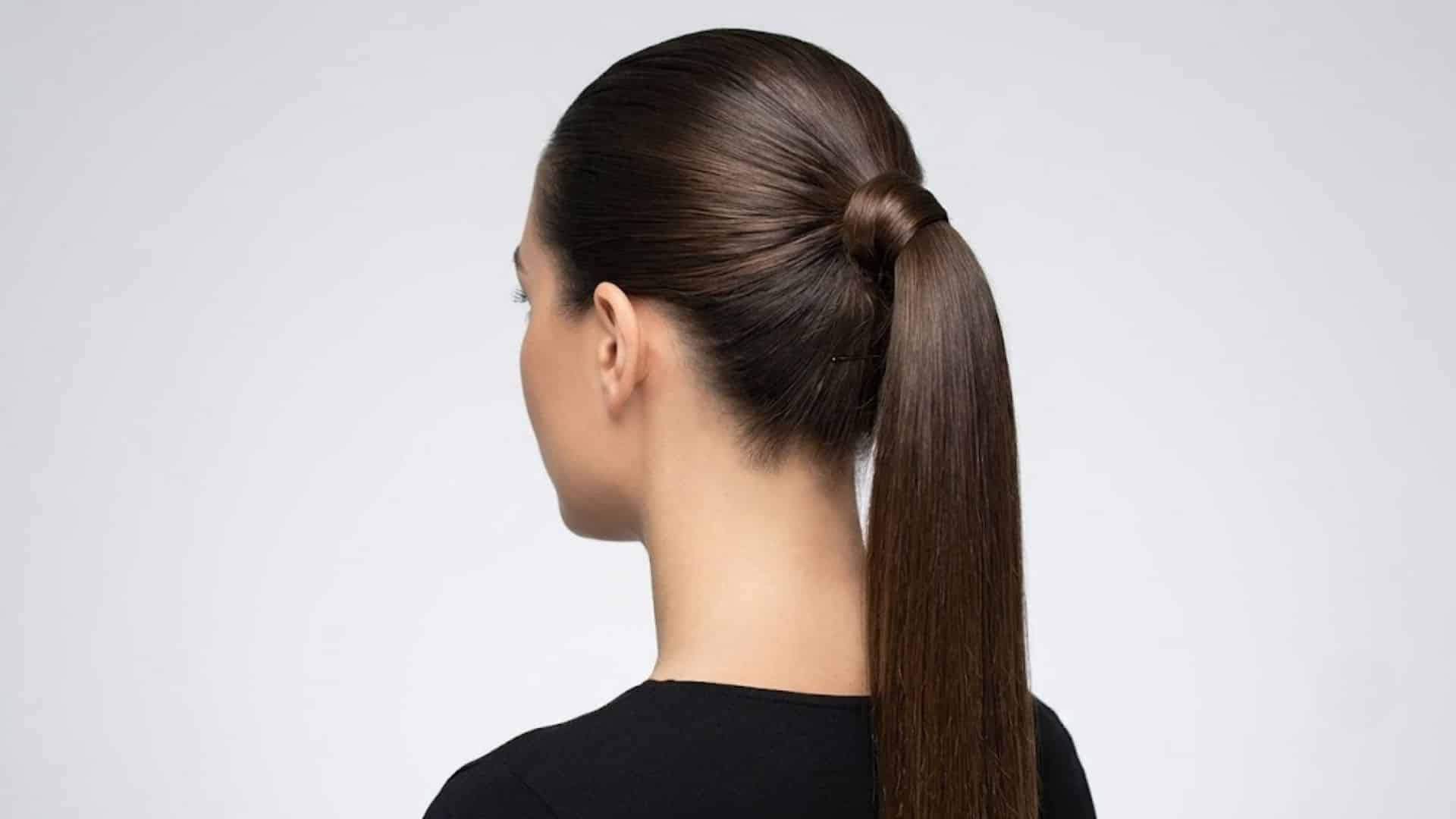 Sleek ponytail with a wrapped strand hiding the elastic tie