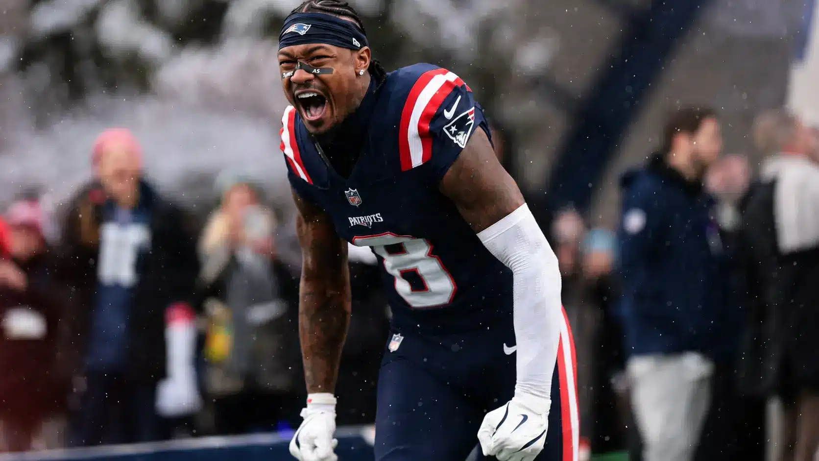 Stefon Diggs in New England Patriots uniform shouting in snow during game celebration with intense emotion roar