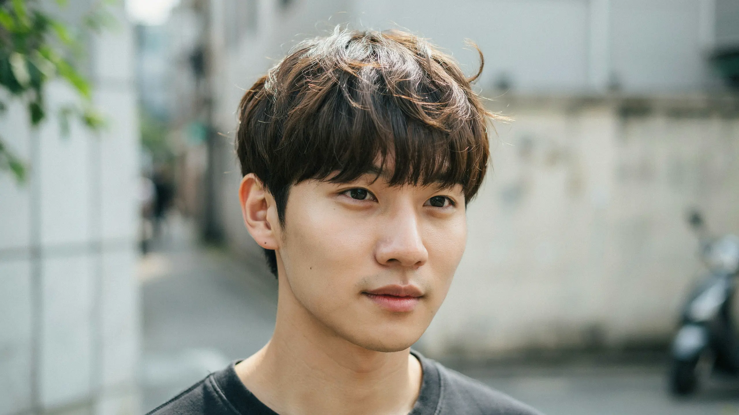 Man showing a textured fringe perm with wavy front layers, natural movement, and a casual Korean-inspired hairstyle.