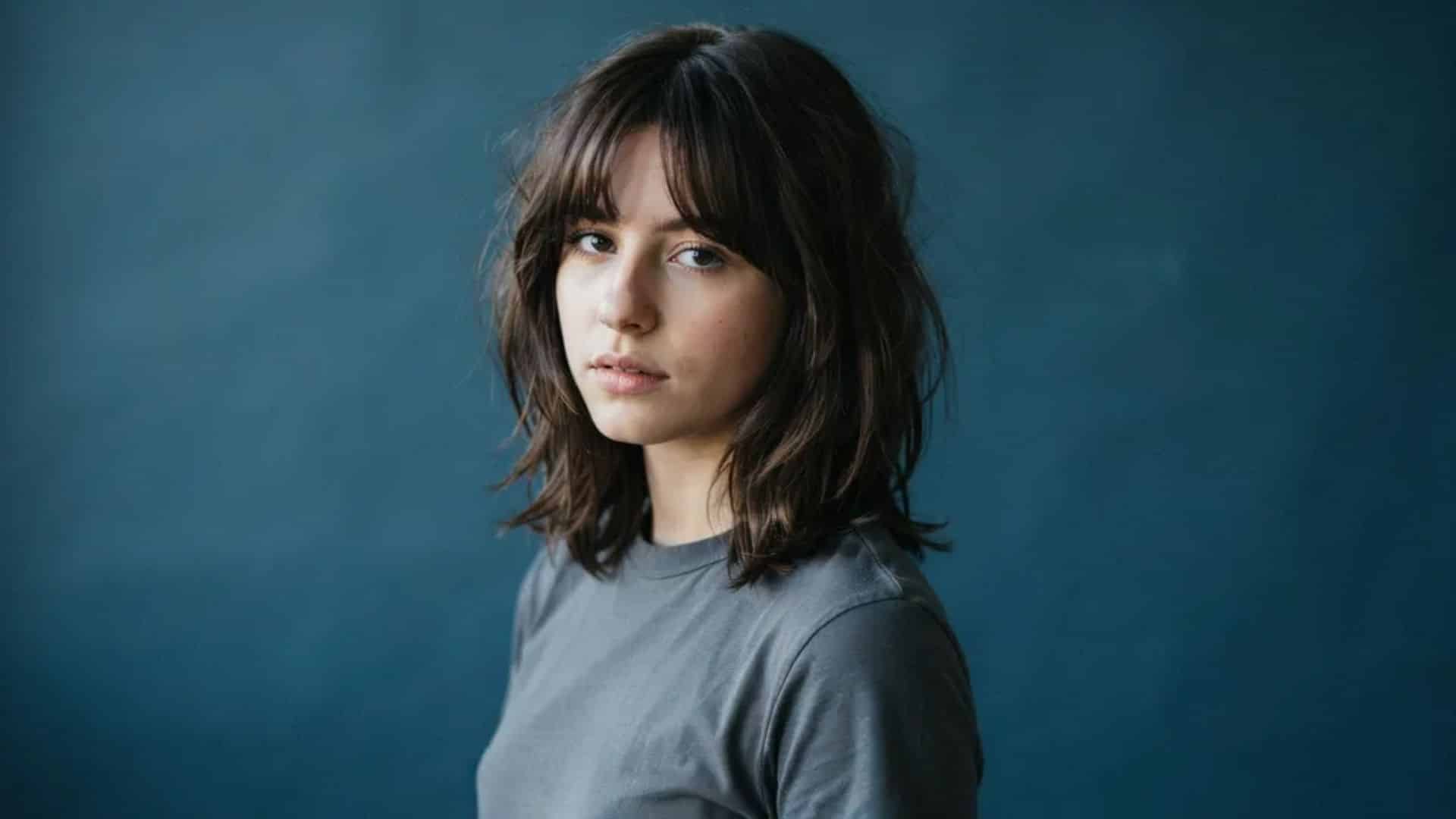Shoulder-length wolf cut with choppy layers and soft curtain bangs.