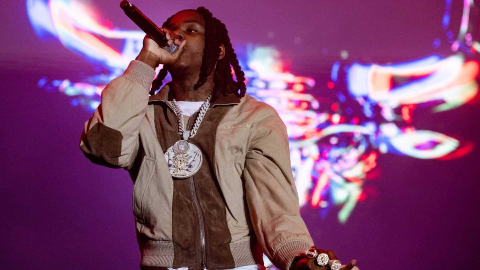 American rapper Polo G performing on stage with a microphone during the announcement of his album Hood Poet.