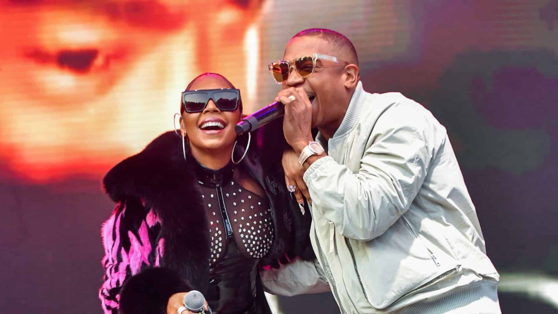Ashanti performing on stage with another artist while holding microphones during a live concert event