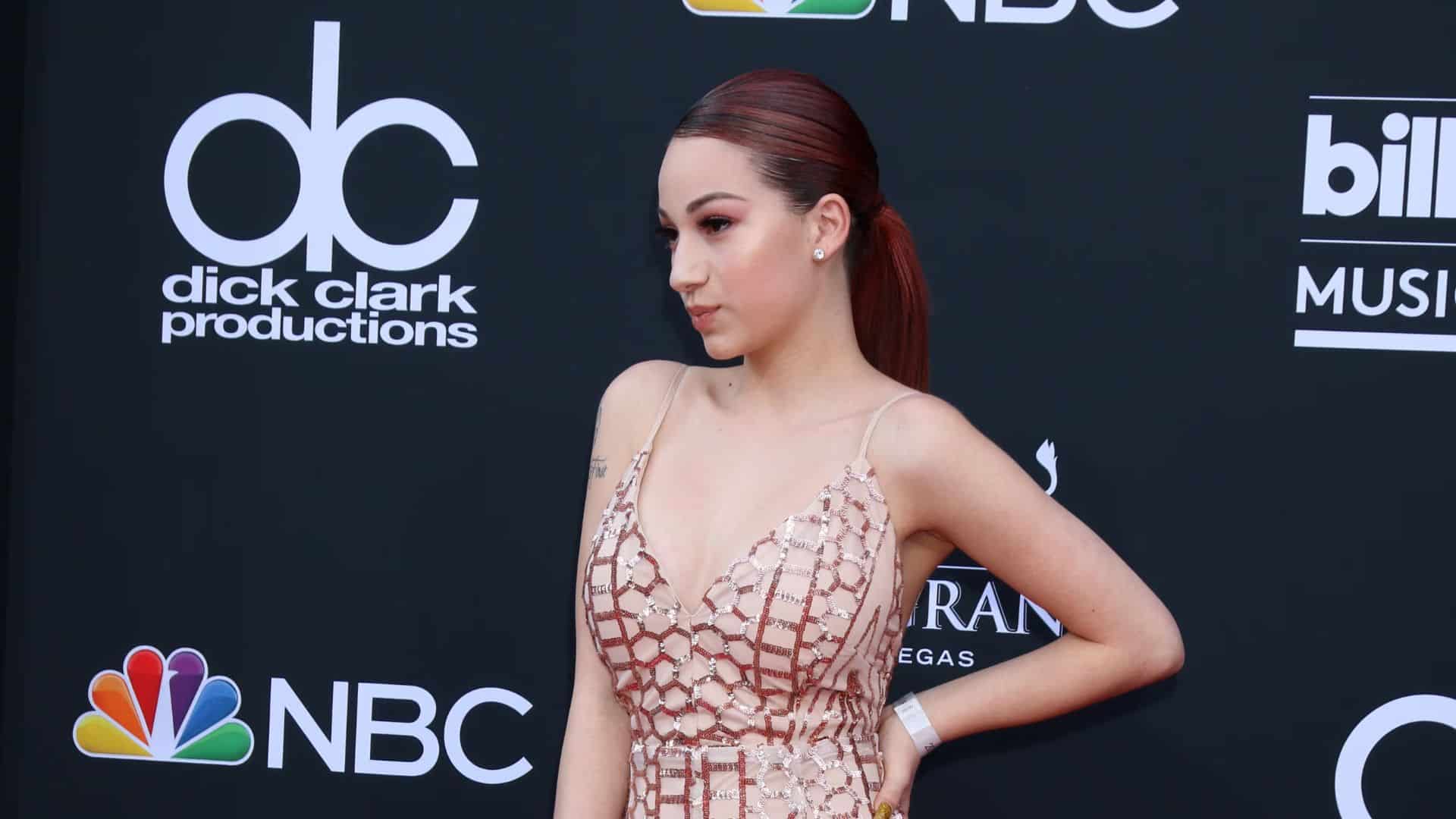 Bhad Bhabie photo showing a woman in a sparkling dress posing at a red-carpet music event.