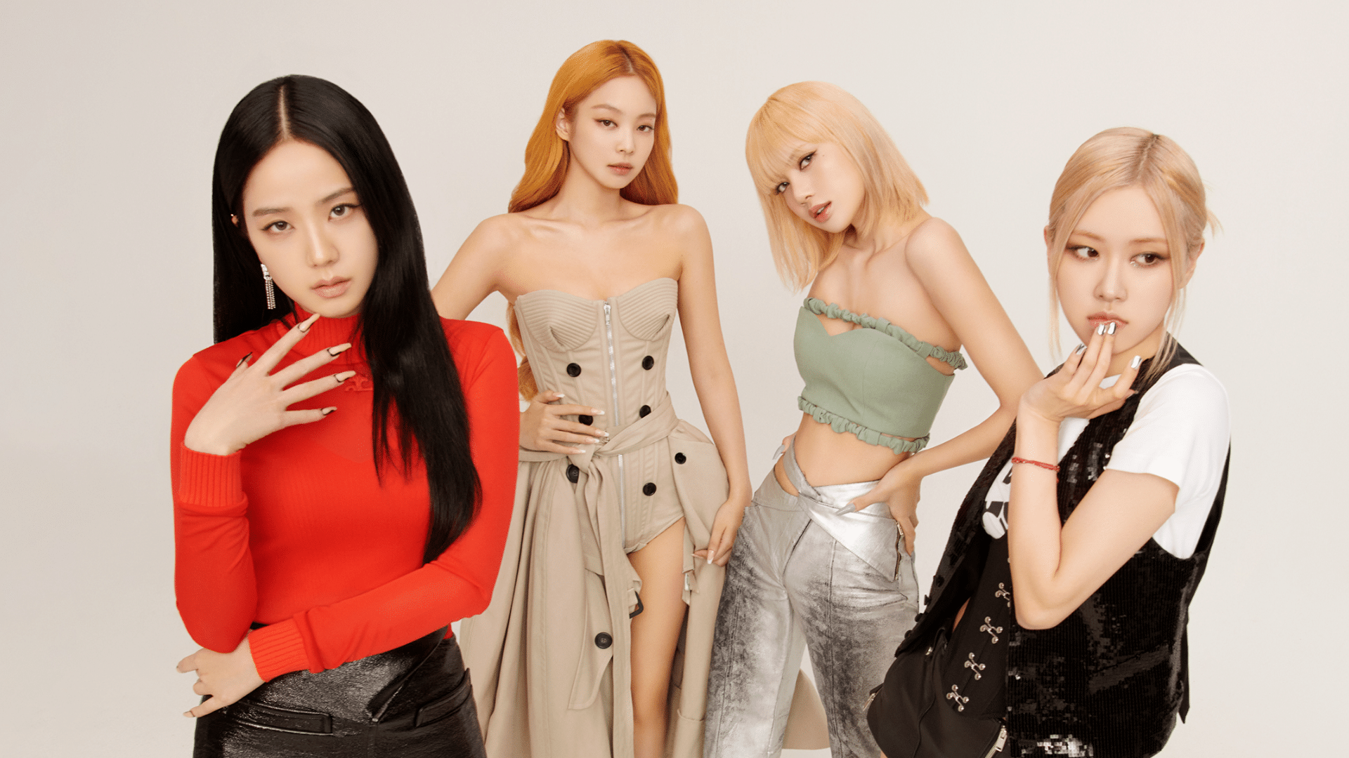 BLACKPINK members posing together in a promotional photo wearing stylish outfits with a clean white studio background