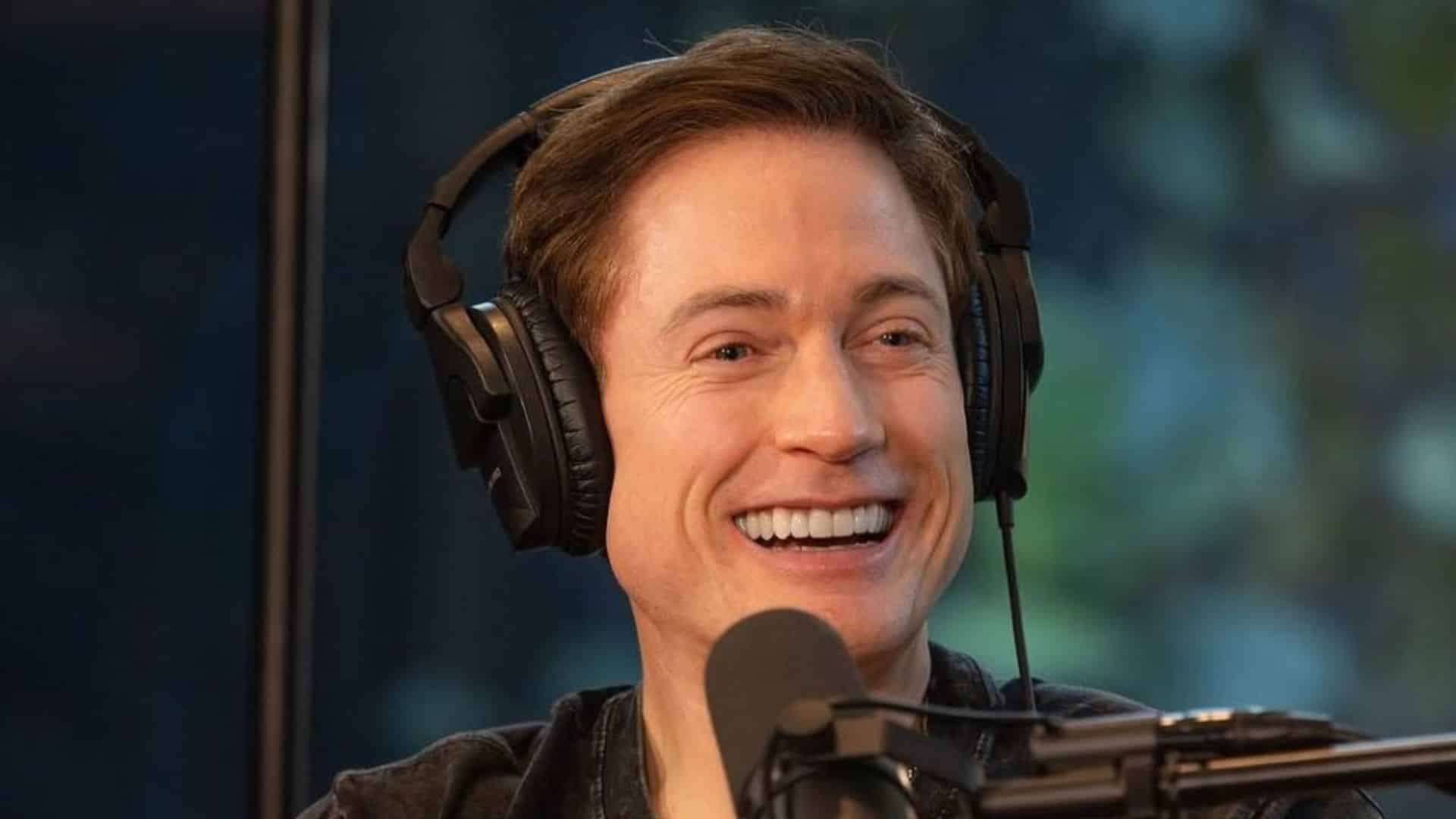 Bryan Johnson smiling during an interview with headphones showing his career journey and financial success timeline details