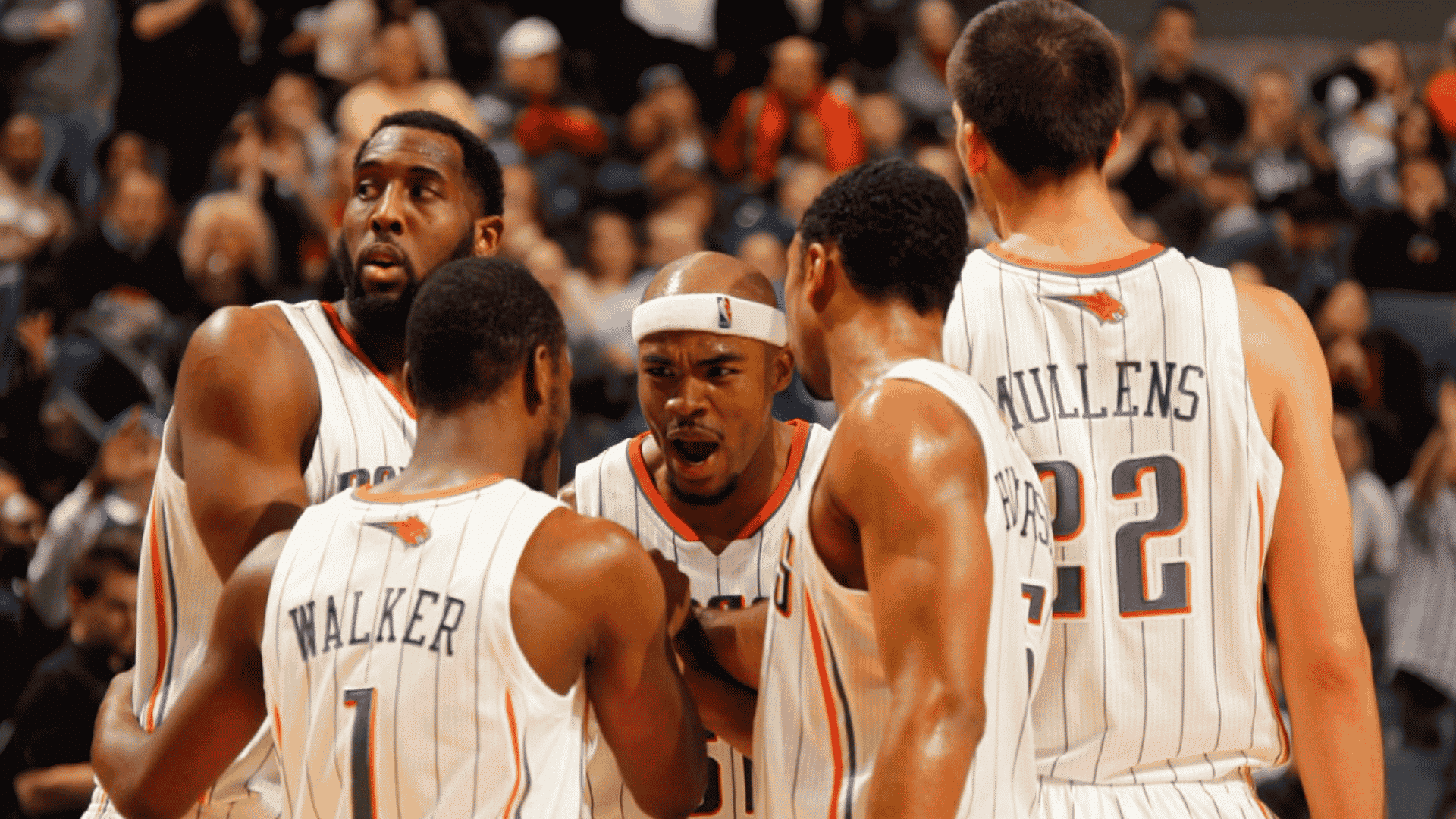 Charlotte Bobcats players, including Kemba Walker, huddle together on the basketball court during an NBA game.
