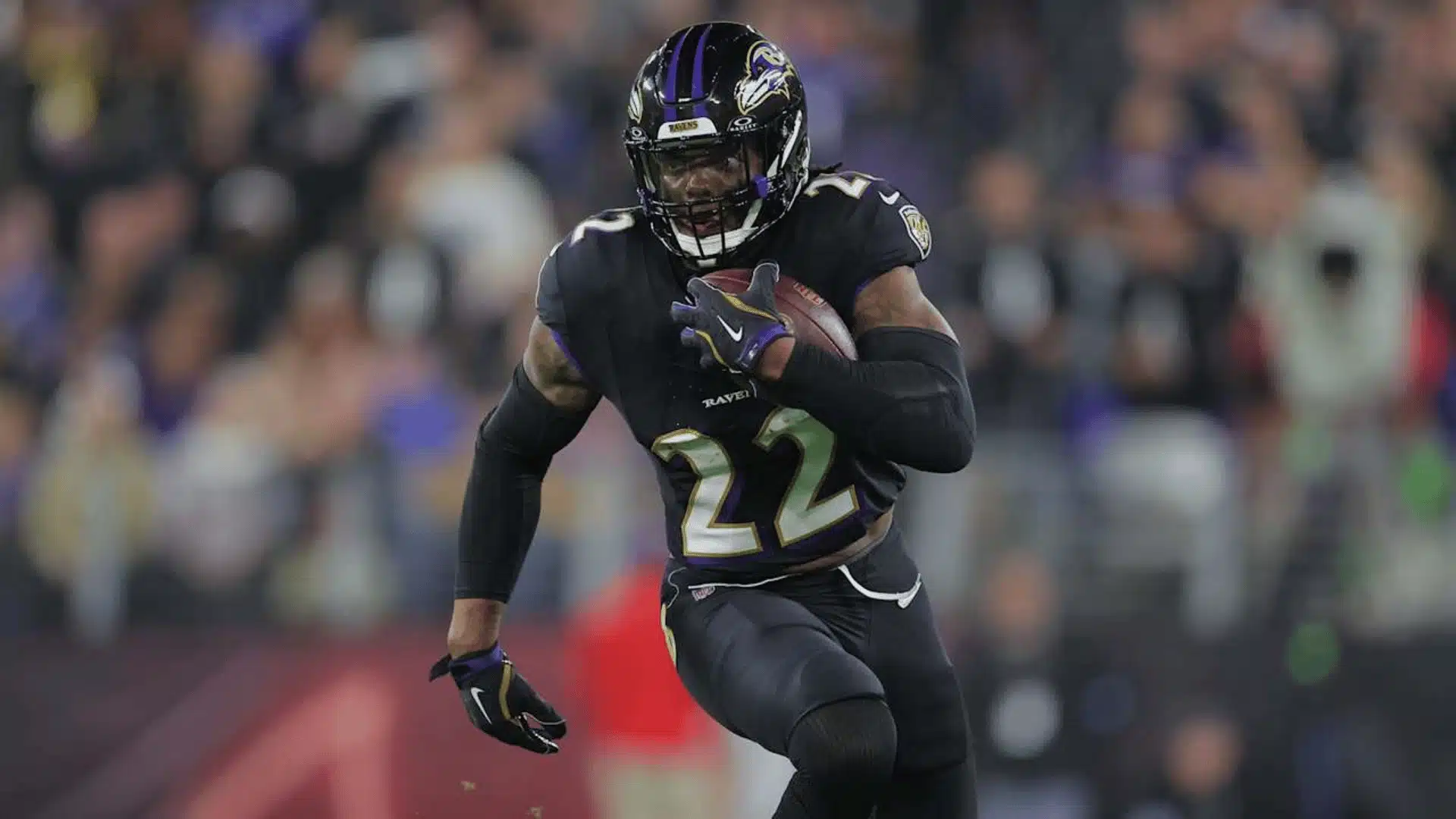 Derrick Henry carries the football while running for the Baltimore Ravens