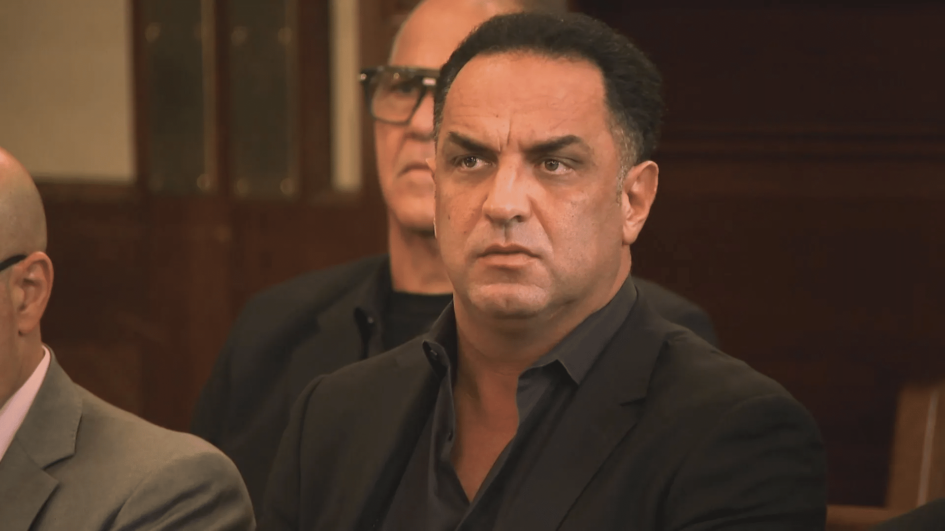 Dino Guilmette posing in a dark suit during a public appearance in the courtroom during his drug case