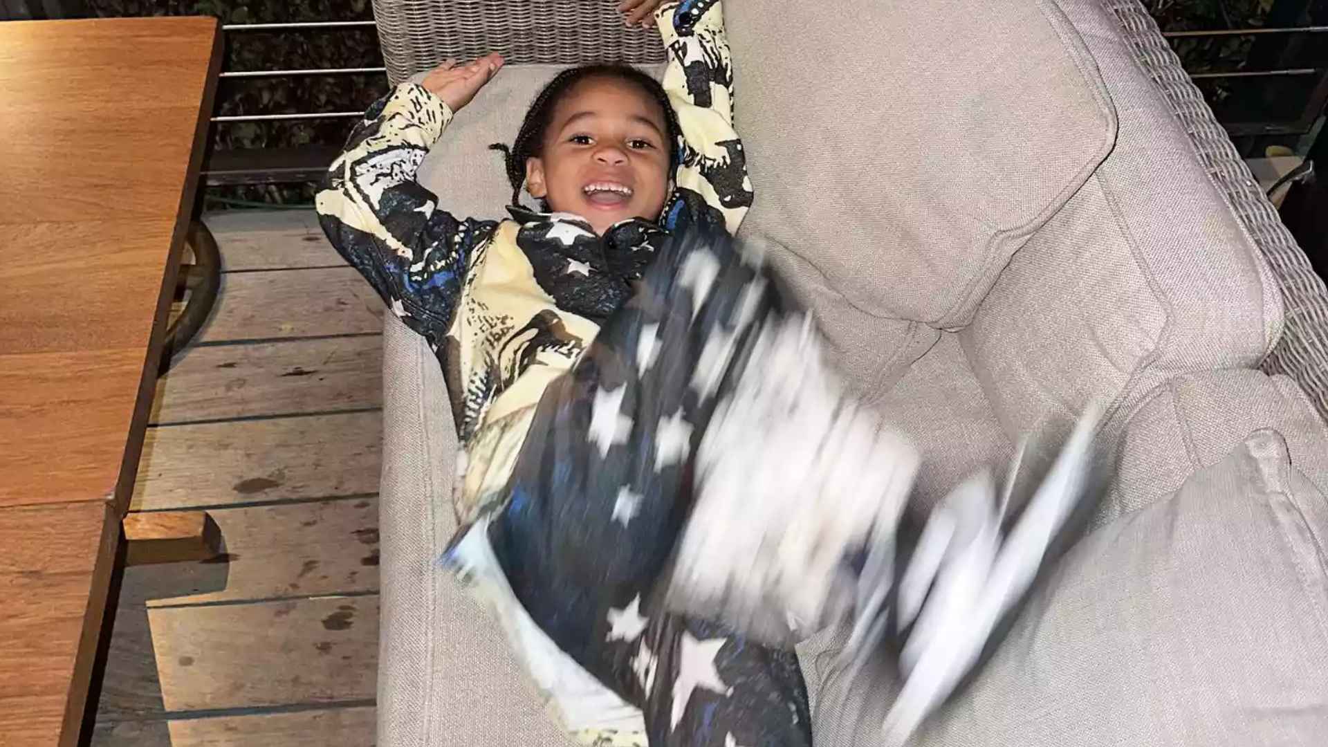 Hendrix Wilburn smiling while relaxing on a couch indoors.