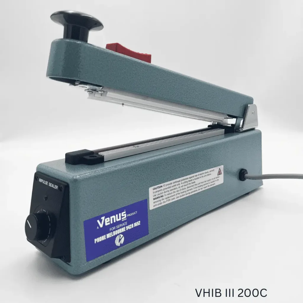 Impulse sealer with open jaws on white background displaying control dial and caution label
