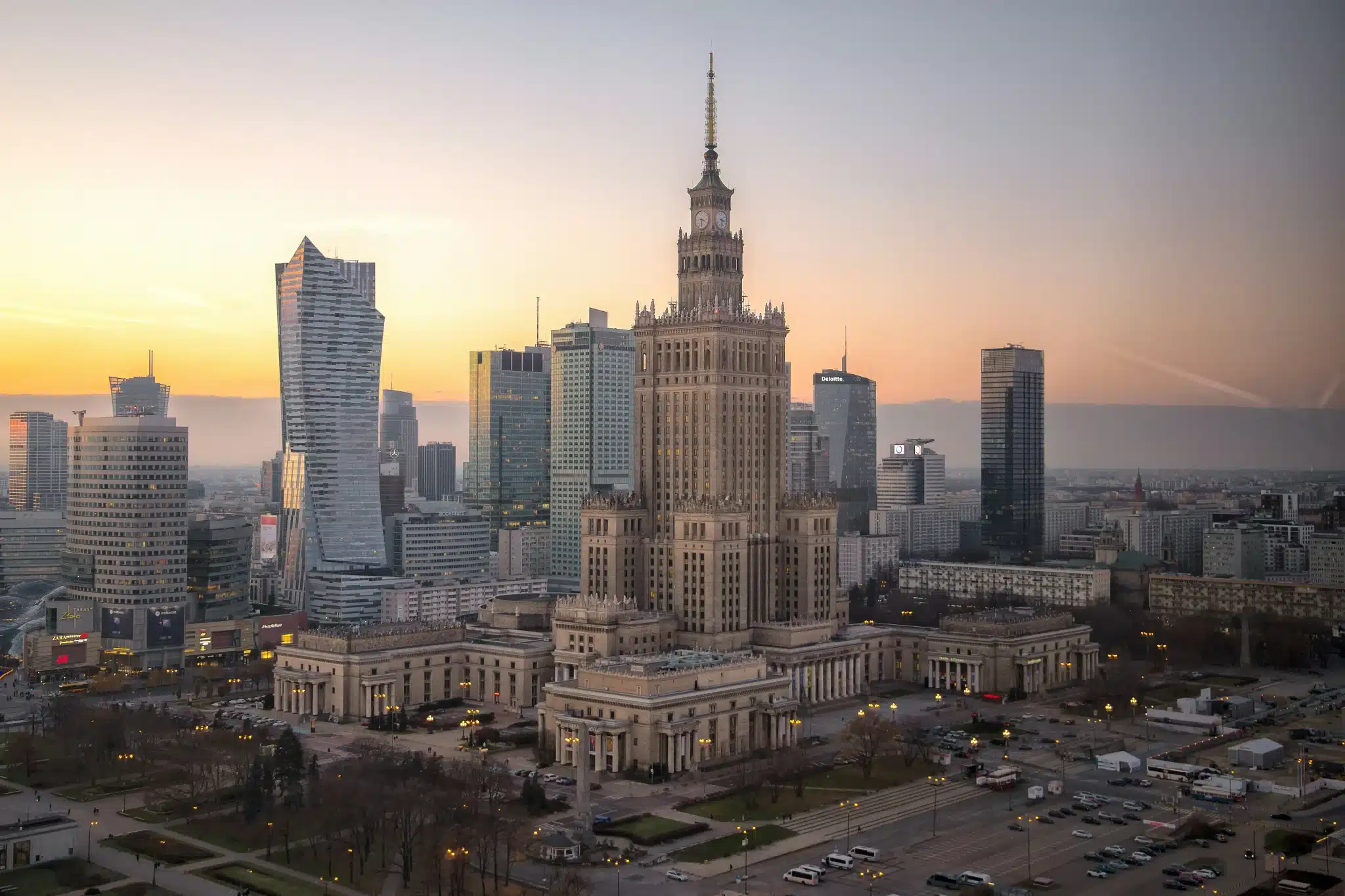 Historic building surrounded by modern skyscrapers at sunset in an urban cityscape