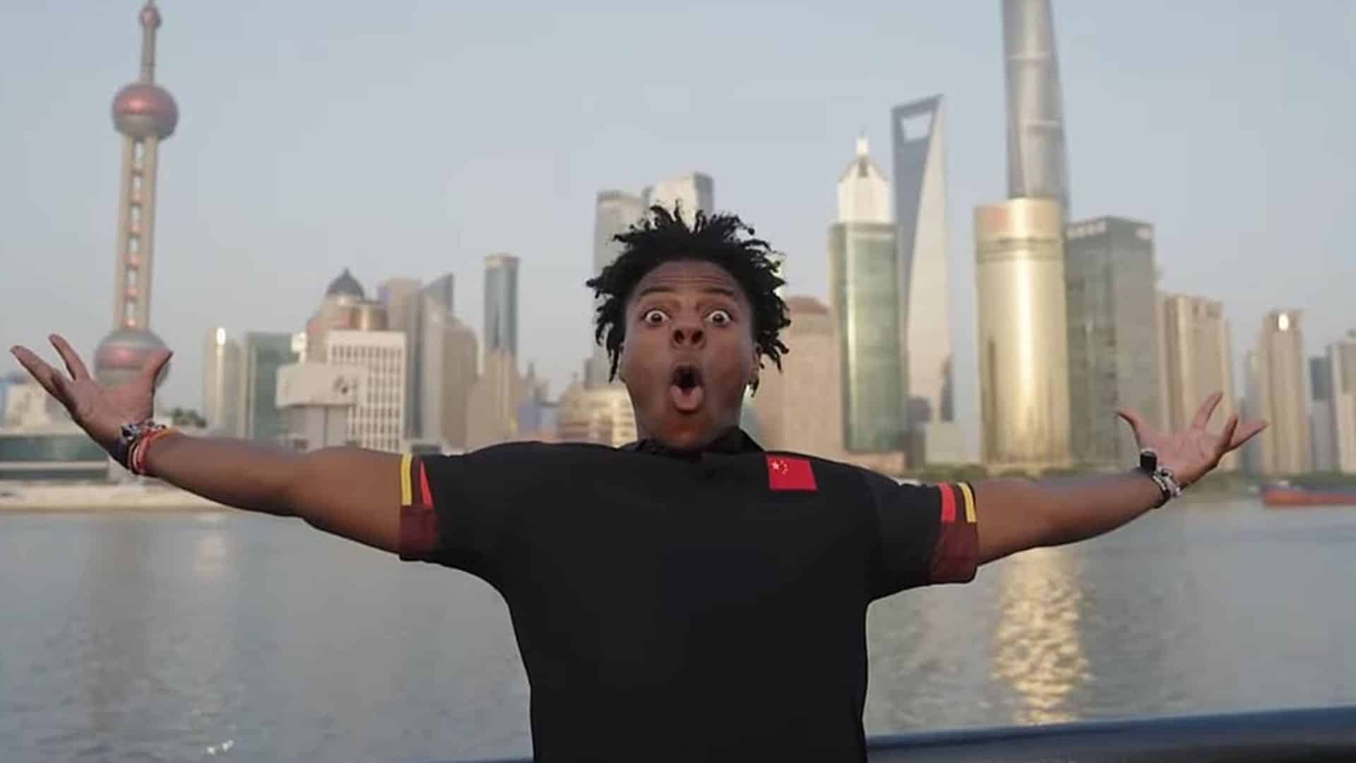 Young male creator stands outdoors with arms open near a city skyline and waterfront during a public travel moment