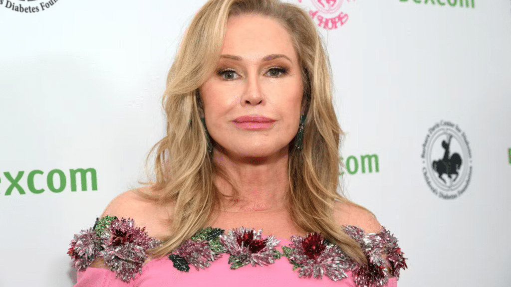 Kathy Hilton wearing a pink floral gown while attending a formal event with a blur backdrop behind her