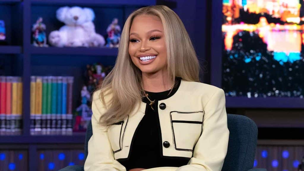 Latto smiling in a black and white outfit during a public appearance