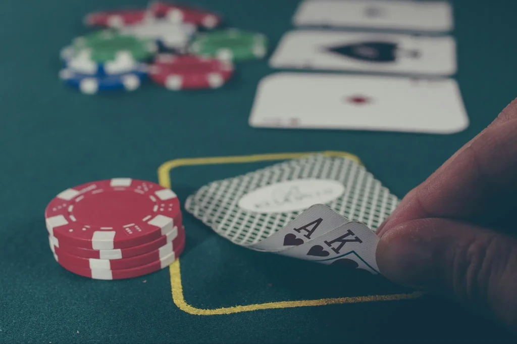 Poker chips and playing cards on green felt table during a card game
