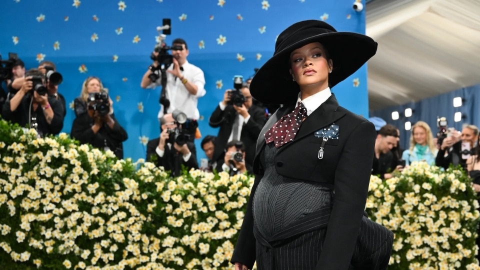 Rihanna wearing a custom Marc Jacobs pinstripe suit and dramatic wide-brimmed hat to debut her third pregnancy at the 2025 Met Gala in New York City.