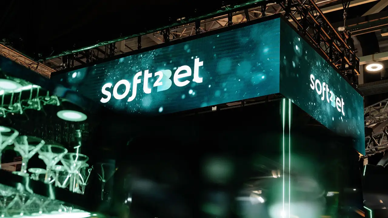 LED digital sign with abstract blue-green background at an indoor event venue