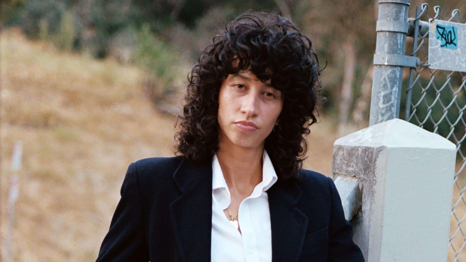 Towa Bird posing outdoors in a black blazer and white shirt.