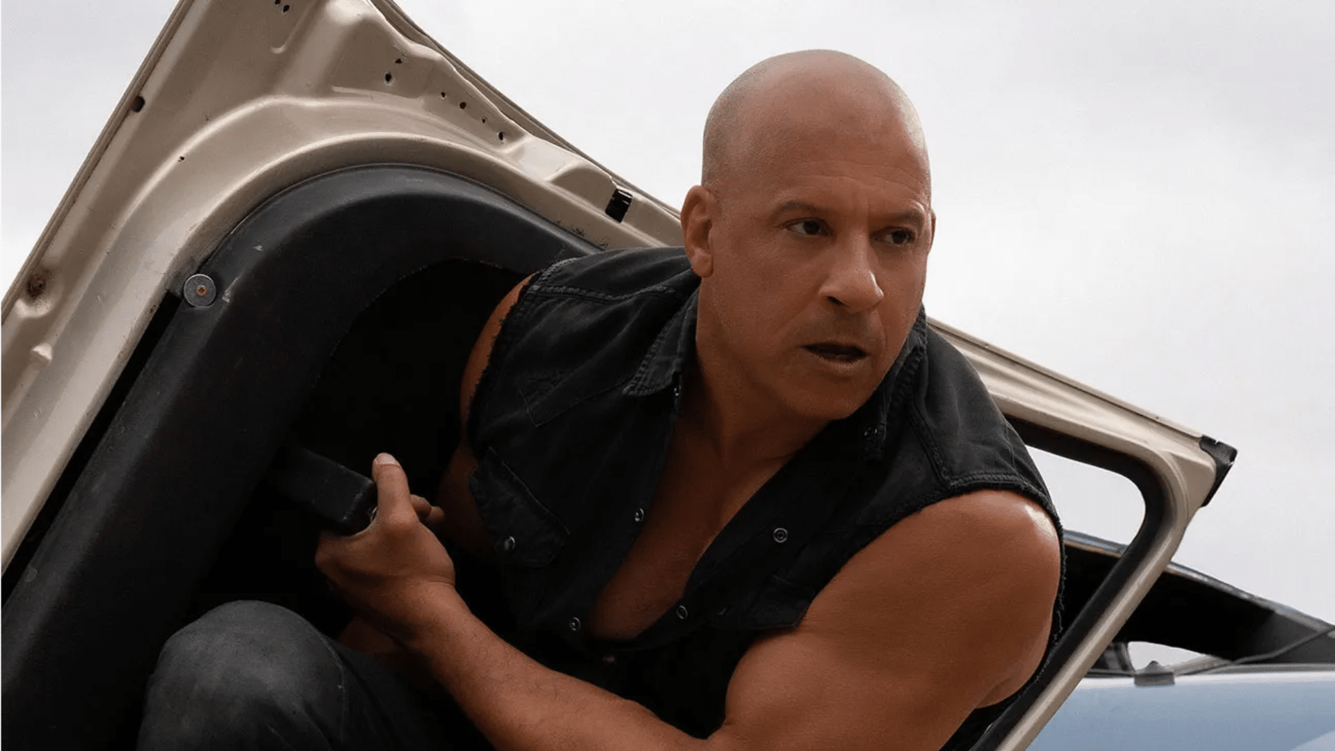 Vin Diesel as Dominic Toretto in a Fast and Furious scene stepping out of a vehicle during an action sequence