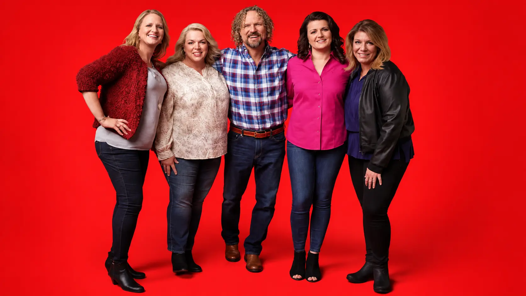 Kody Brown with All 4 'Sister Wives' smiling and posing in studio with bright red background wearing casual outfits